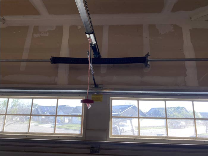 Repaired garage door spring mechanism ensuring smooth, quiet, and reliable door movement.